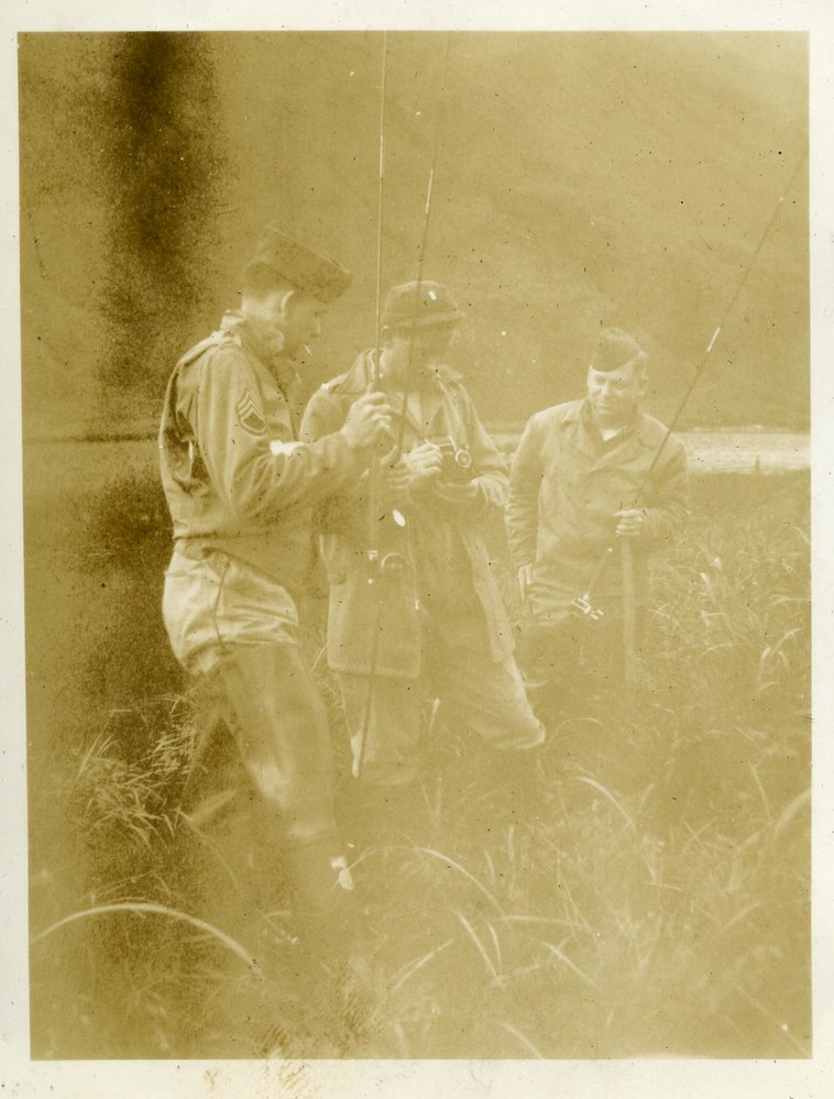 Three men hold fish