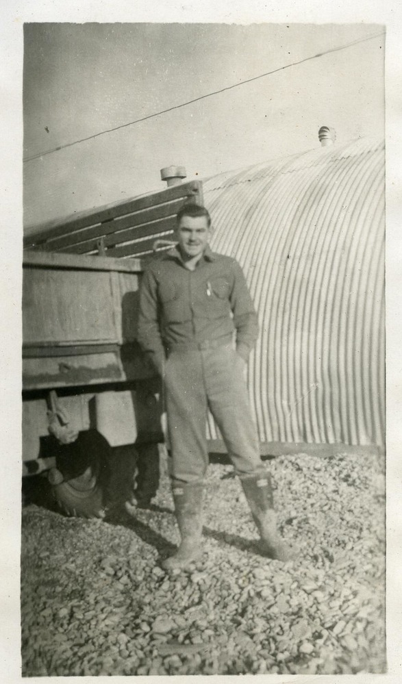 Man posing by quonset hut