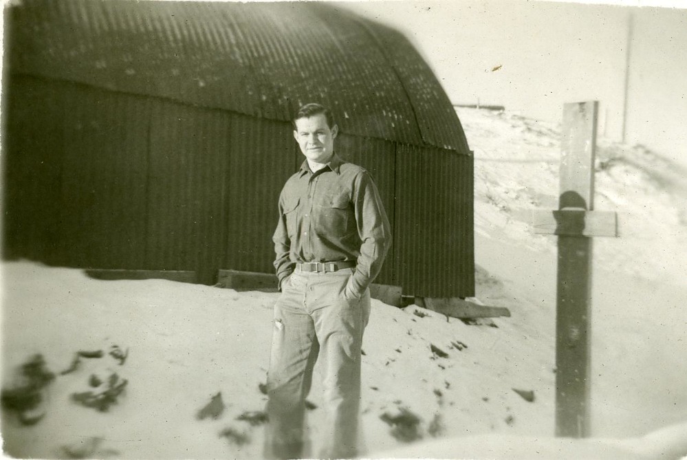 Man posing by quonset hut