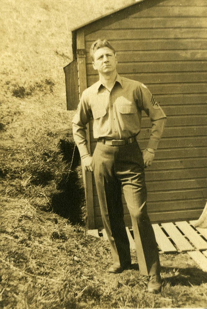 Uniformed man posing by building