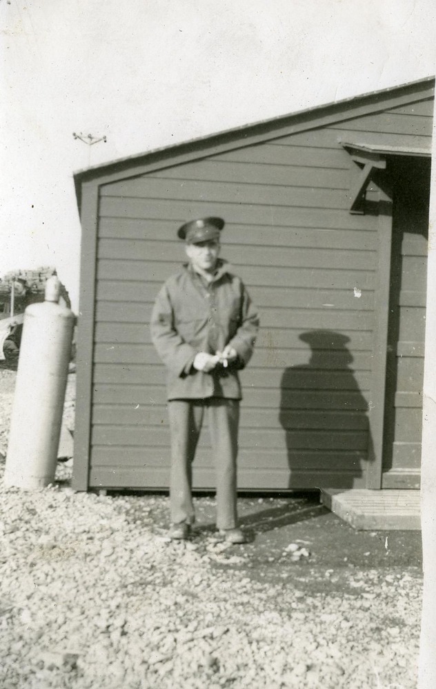 Uniformed man by building