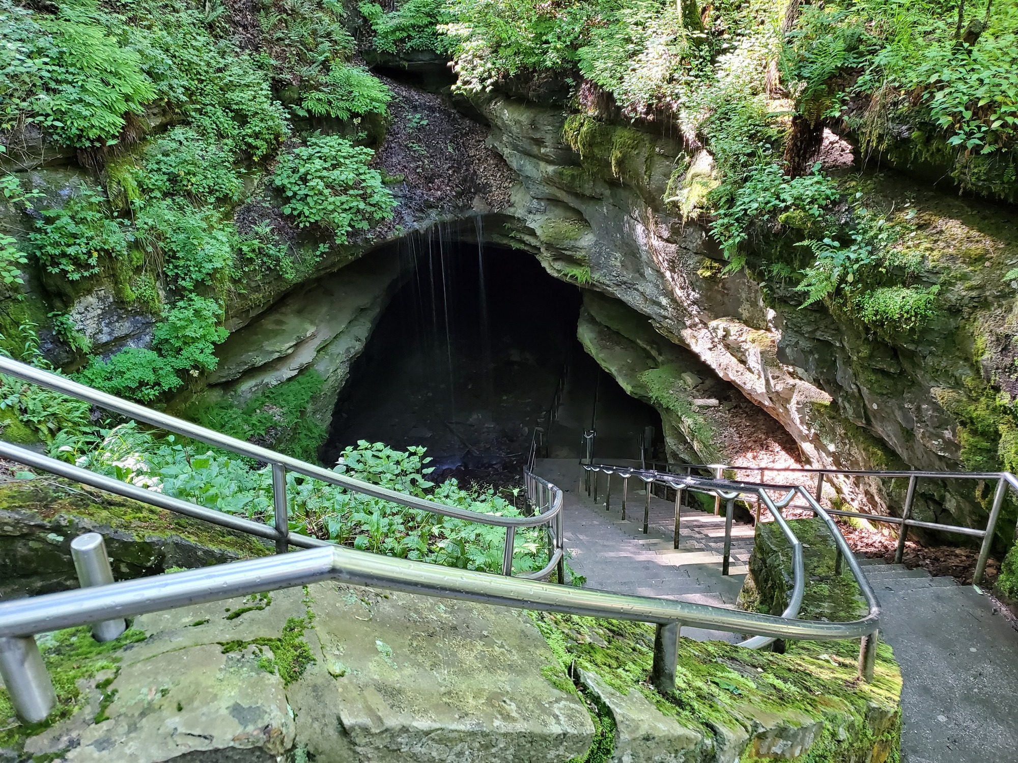 A large staircase leads into a cave entrance from the surface. 
