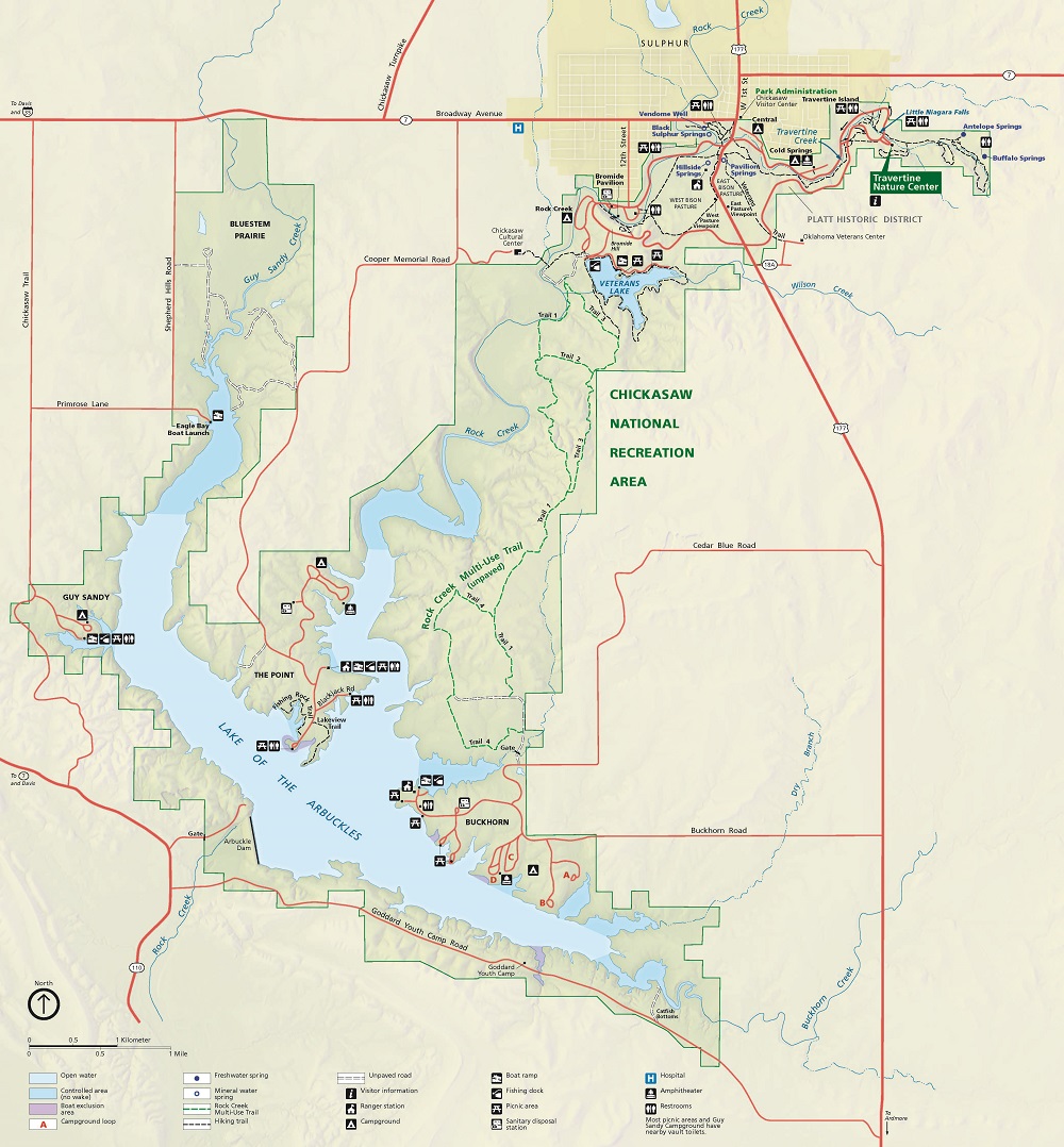 Area map of Chickasaw National Recreation Area in Oklahoma. The capital letter T-shaped park is shaded green and contains a grid of highways represented with red lines. The rivers are shown as blue lines, and the background is beige. 
