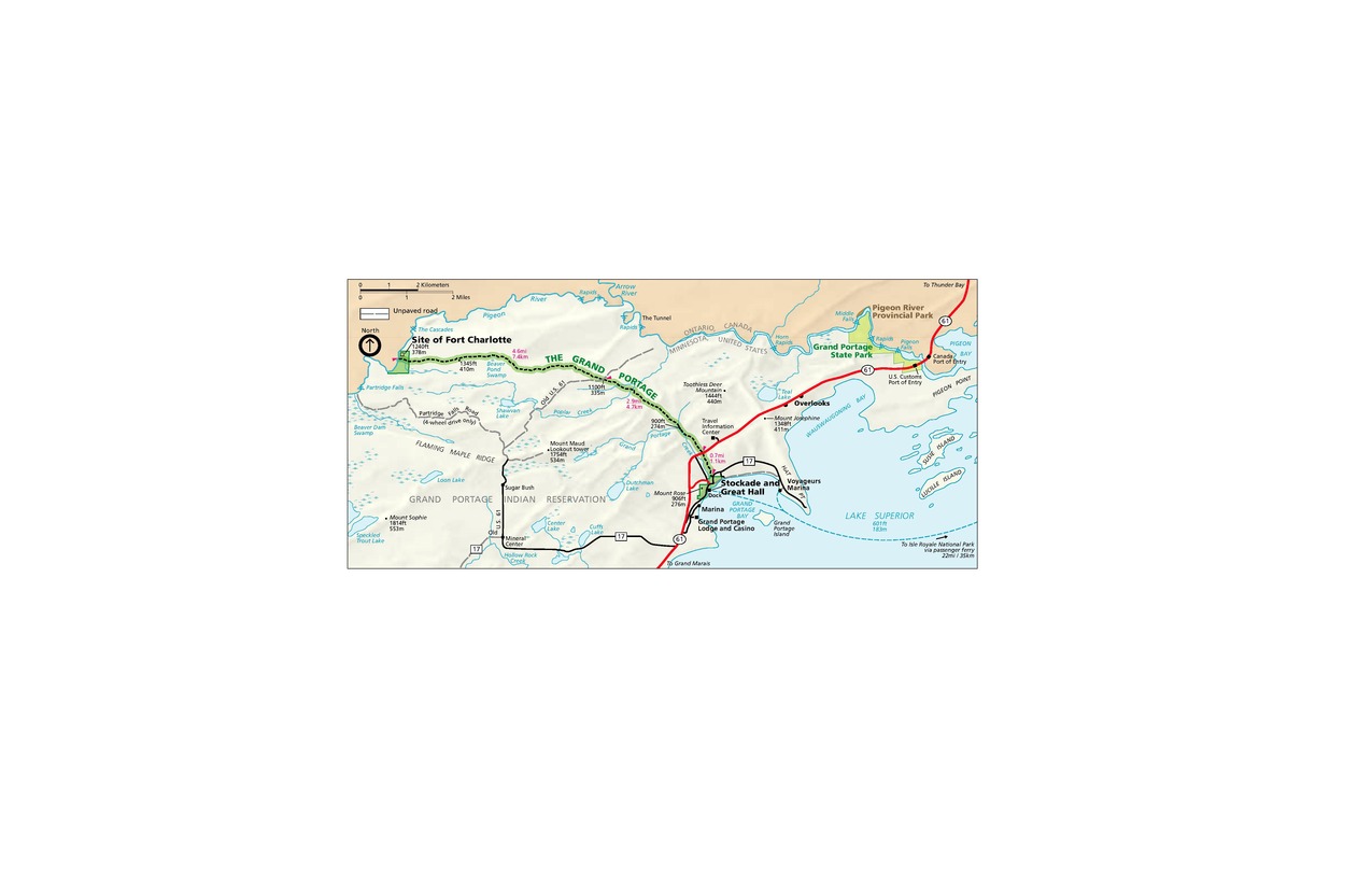 Map of Grand Portage National Monument in Minnesota. Beige-colored land representing Grand Portage Indian Reservation fills most of the left half of the map before curving up and over Lake Superior in the lower right quadrant. Bodies of water are shown in blue and land to the north in peach.
