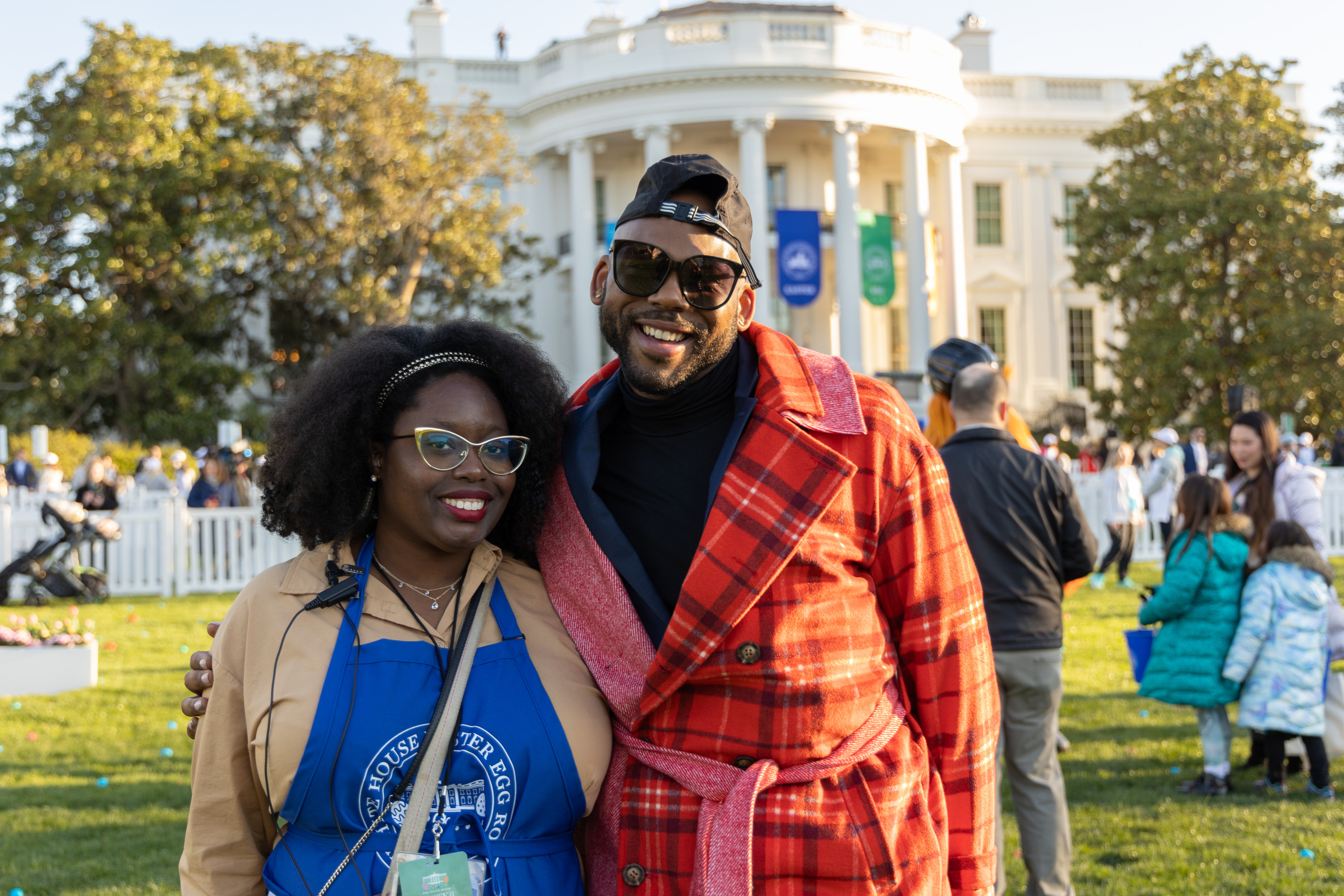 Two volunteers stand in front of the White House