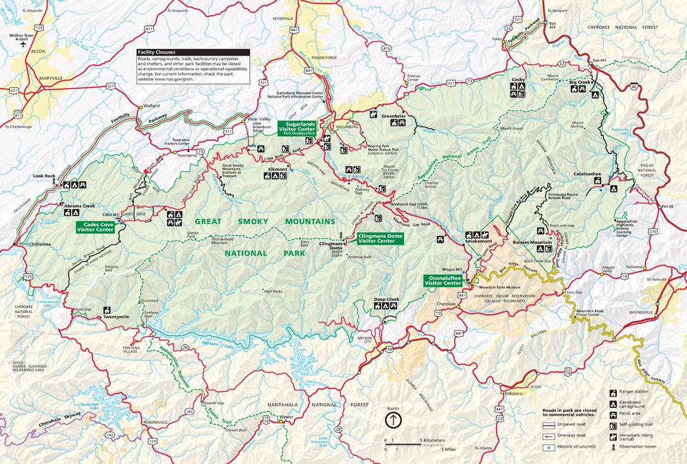 Map of Great Smoky Mountains National Park in North Carolina and Tennessee. Park terrain is shown in green; surrounding areas in white, beige, or orange; cities and towns in yellow; and roads in red or black.