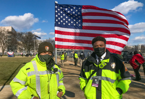 A National Park Service employee and D.C. government employee standing next to a U.S. flag