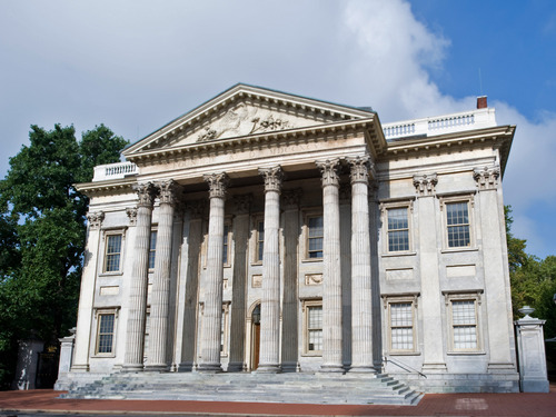 Two-story 18th century marble building with pediment and six columns.