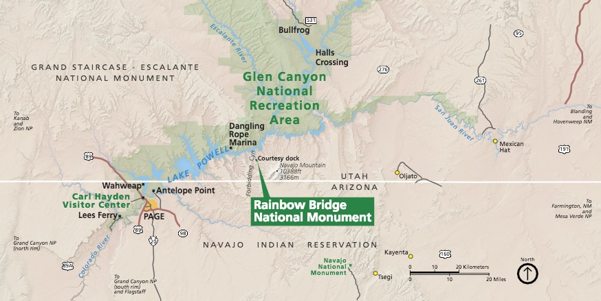 Area map of Rainbow Bridge National Monument in Utah. A straight white horizontal line separates Utah above to Arizona across the bottom third of the map. The monument is labeled with a green callout box. Other parks are shaded green or tan.
