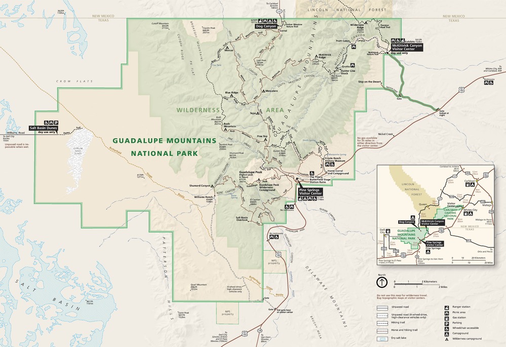 Map of Guadalupe Mountains National Park in Texas. The park has an irregular circle shape and is outlined in dark green, and the area within it is tan and pale green. The surrounding area is light beige, and trails are represented by dashed and dotted lines.