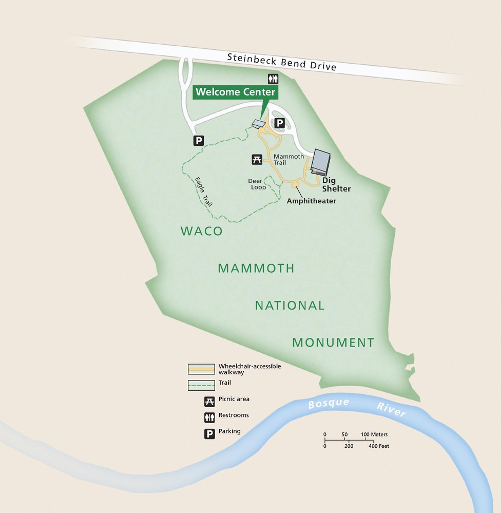 Map of Waco Mammoth National Monument in Texas. The park, shown in green, stretches between Steinbeck Bend Drive in the north and the Bosque River in the south. A Welcome Center, Dig Shelter, and trails are clustered in the northeast. 