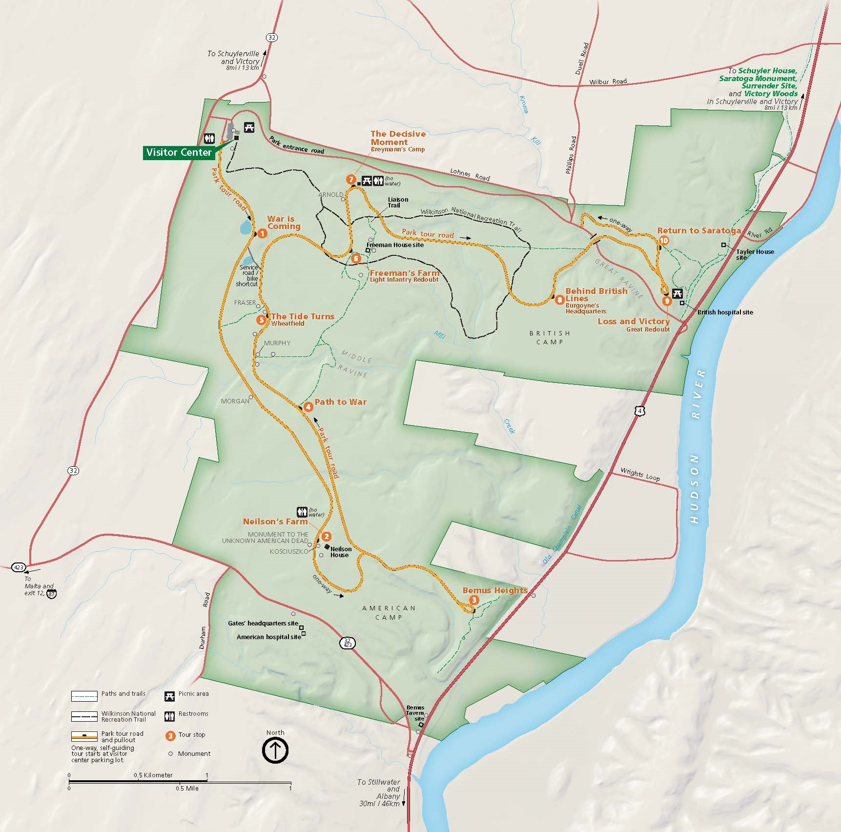 Map of Saratoga National Historical Park in New York. The park area, shown in green, is shaped like a blocky letter E. West of the Hudson, the park touches the riverbank at two points. The map shows roads around and through the park, including the self-guiding park tour, as well as paths and trails.