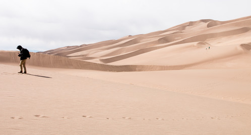 A park visitor walks across the dunes