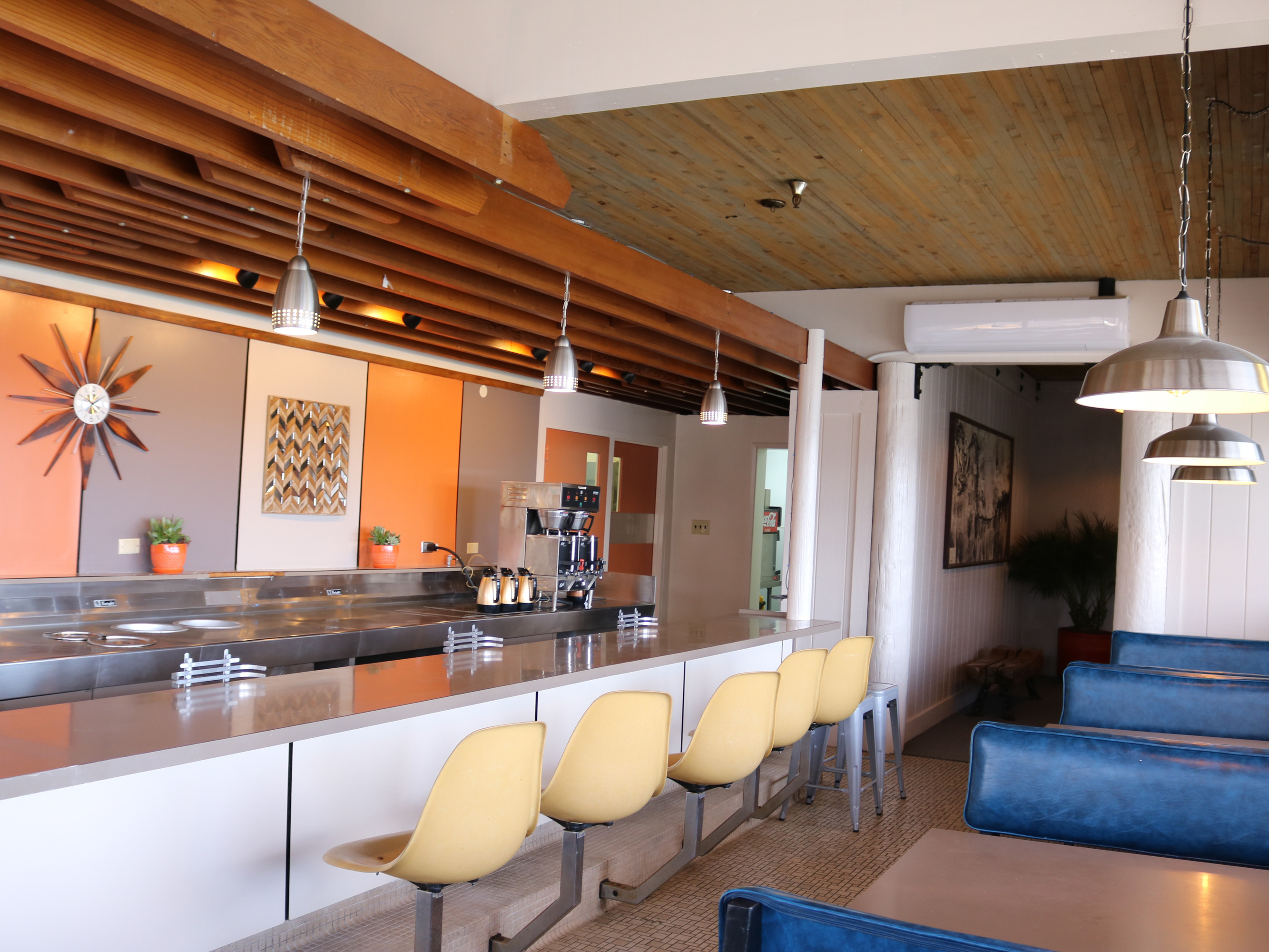 diner counter with yellow bar stools and blue booths