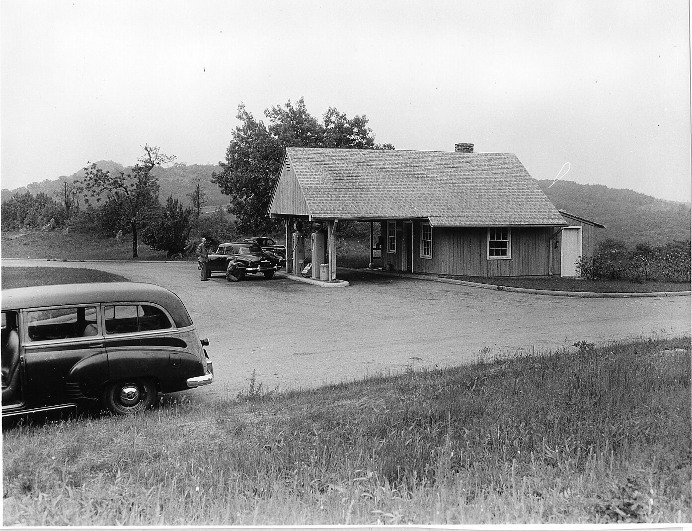 Vintage cars in front of a gas station