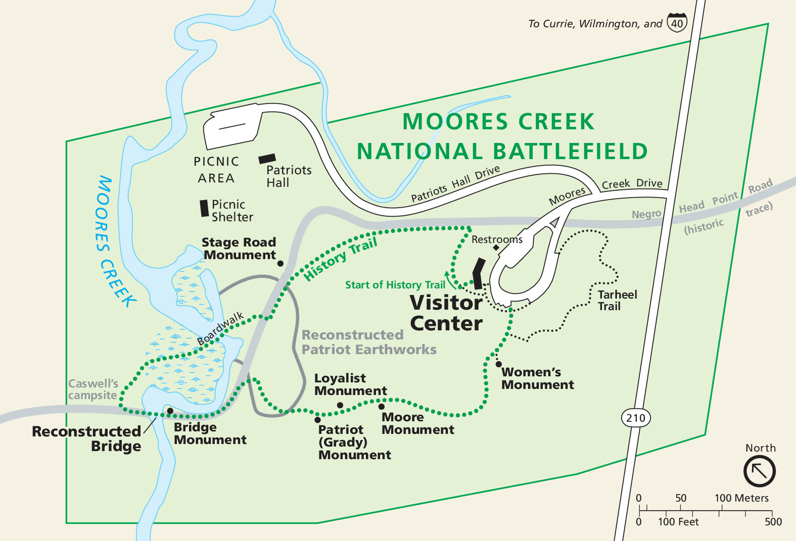 Park map of Moores Creek National Battlefield in North Carolina. The park is outlined and shaded green, and the surrounding area is tan. Green dotted and black dotted lines represent trails.