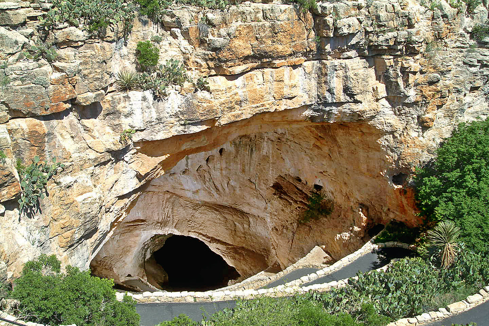 Switchbacks on a paved trail lead into the natural entrance of Carlsbad Caverns