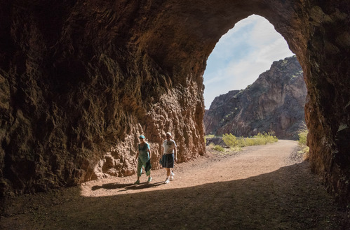 People walking through one of the five tunnels at the historic railroad trail