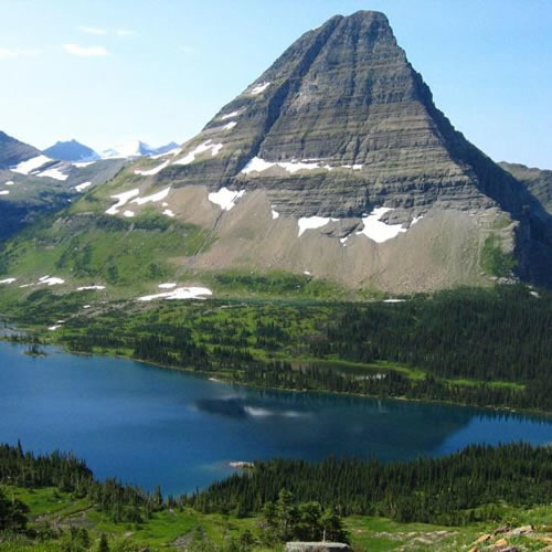 A blue lake in front of a mountain.