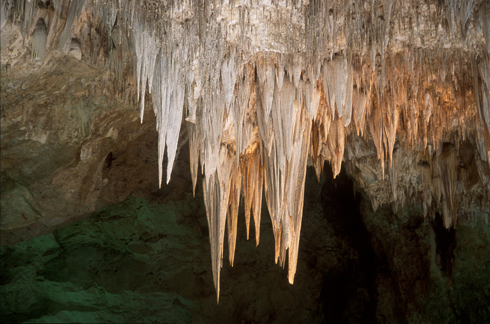 A set of large stalactites hangs from the ceiling.