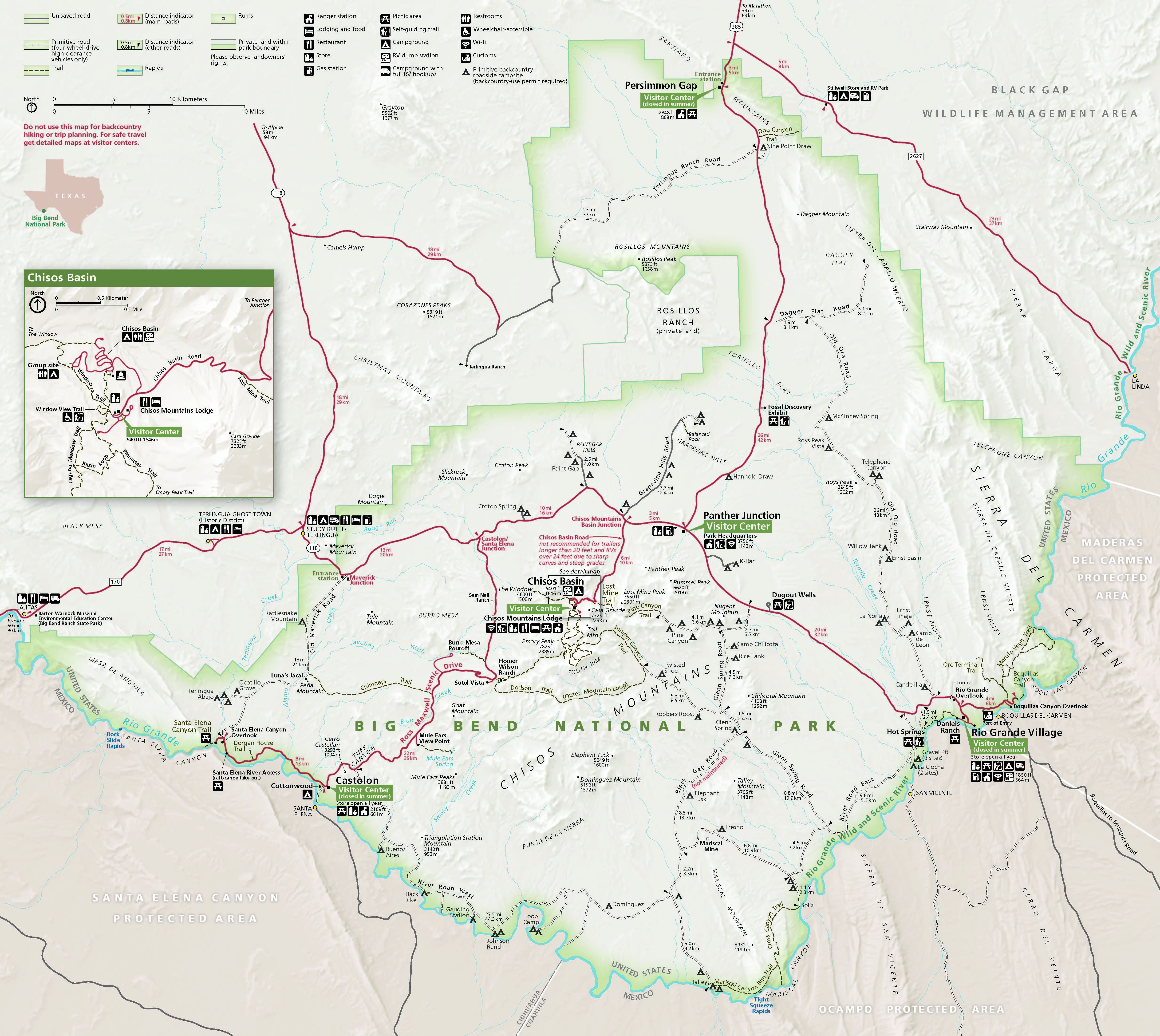 Map of Big Bend National Park in Texas. Outlined in a shade of faint green, the park is roughly oval with stepped borders and two short arms reaching to the northwest from the top and left edges. Surrounding terrain is shown in beige for the US or darker tan for Mexico, and solid red, gray, or black double dashed lines create a web of roads in and around the park.
