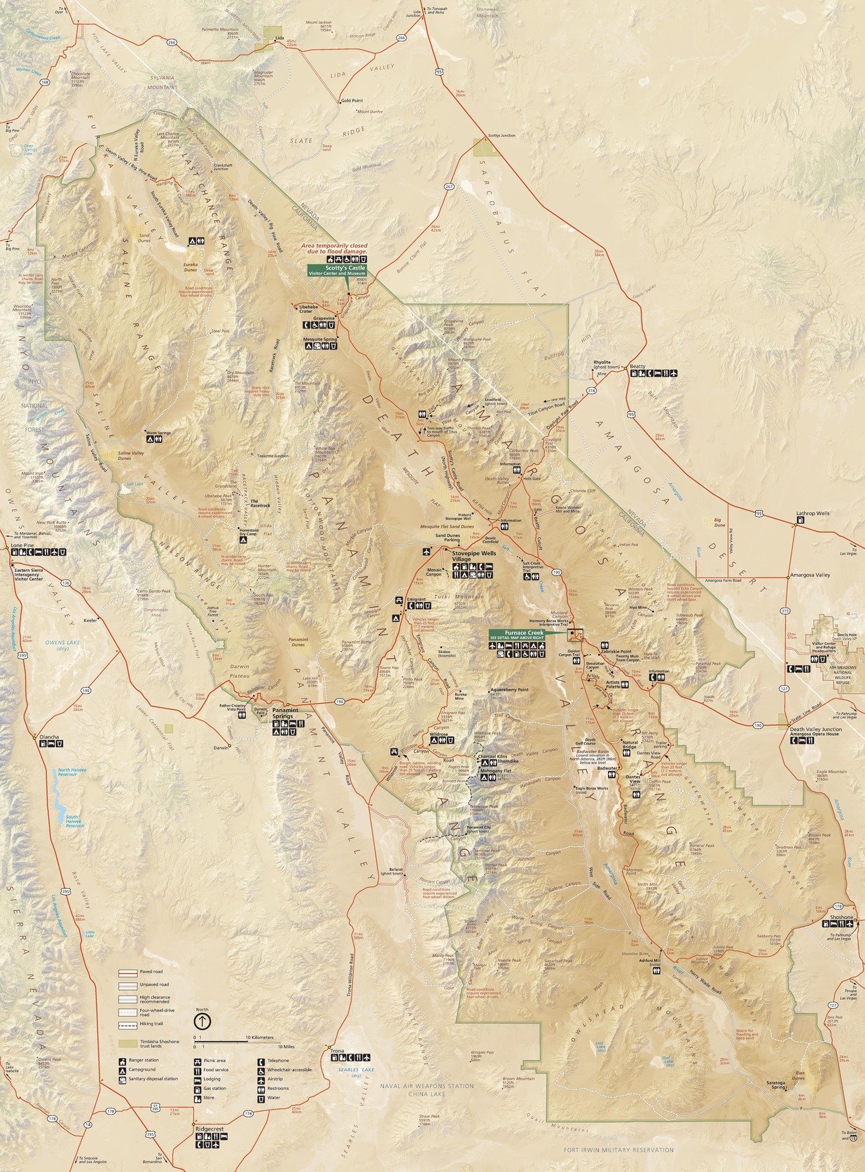 Map of Death Valley National Park in California and Nevada. The park’s border is green and irregularly ruffled in shades of pale tan and sand brown with ridgelines in bone white. Dozens of sites, roads, peaks, valleys, and other features are labeled.