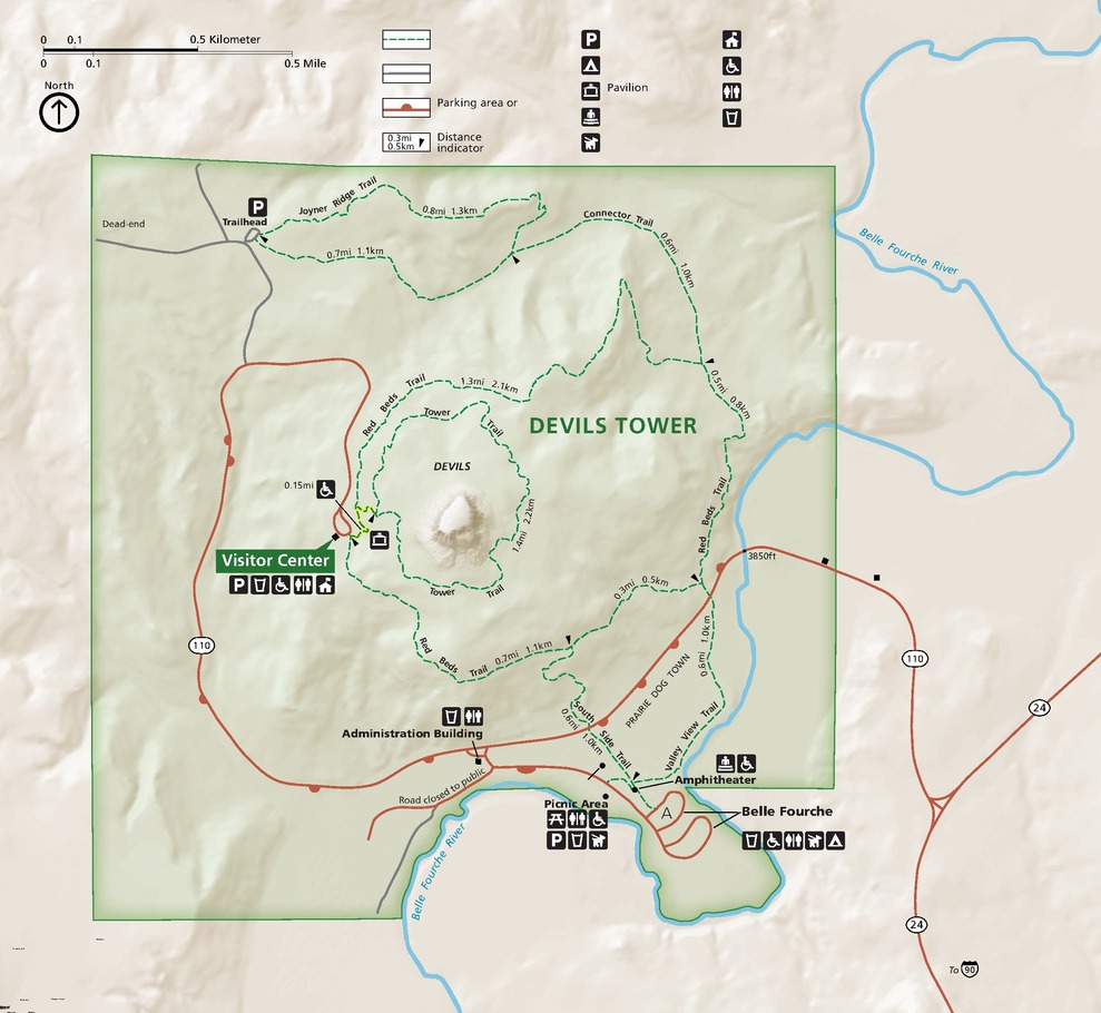 Map of Devils Tower National Monument in Wyoming. The mostly square park is shaded green, and surrounding terrain is beige. The Belle Fourche River is shown as a blue line, and roads are shown as red.