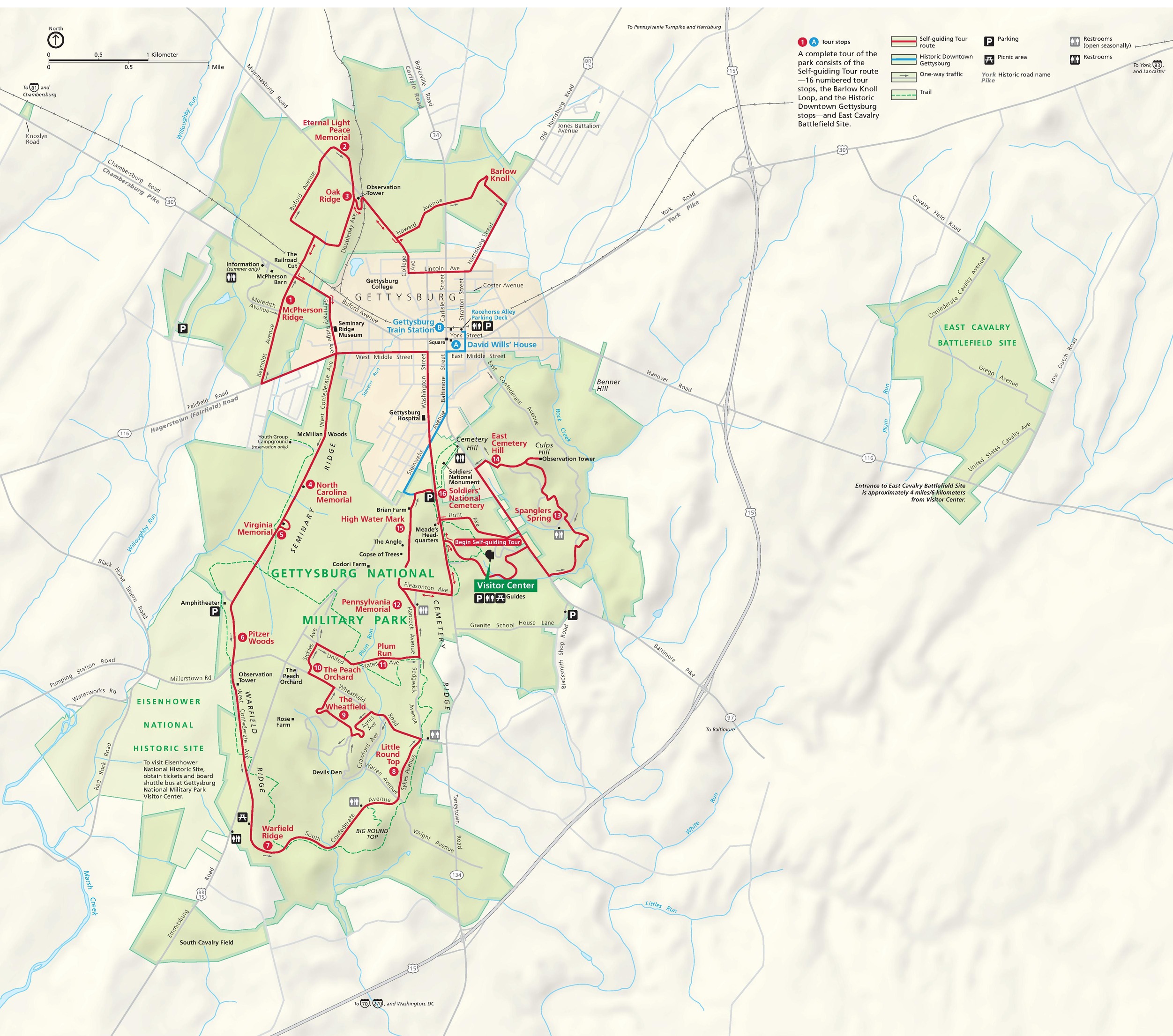 Map of Gettysburg National Military Park in Pennsylvania. The park is highlighted in green with the surrounding area in tan. A solid red line weaving through the park represents a self-guided tour route.