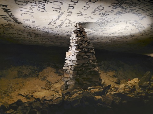 A large stacked stone monument and historic signatures. 