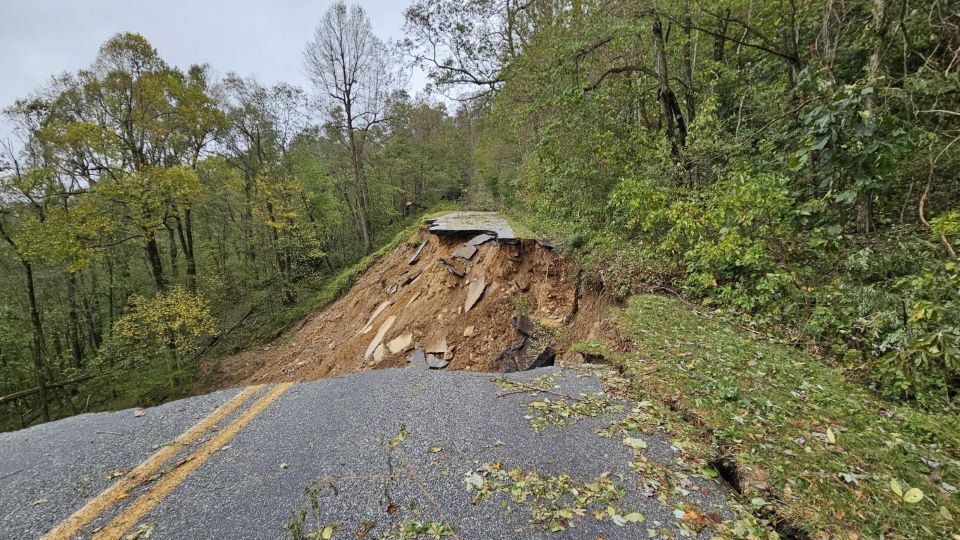 A jagged line of asphalt gives way to a vast expanse of nothingness where the full width of the roadway has collapsed.