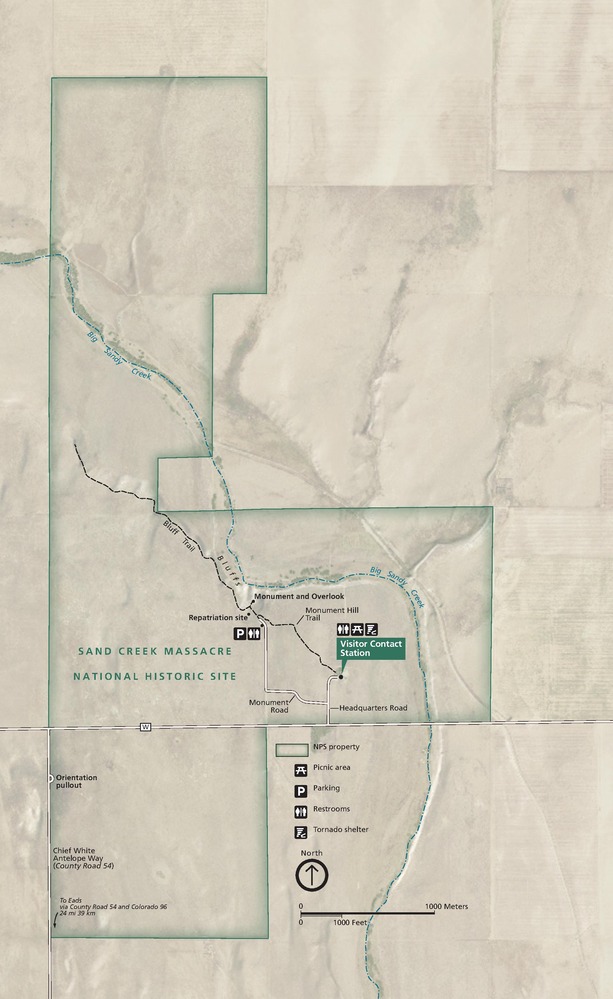 Map of Sand Creek Massacre National Historic Site in Colorado. Shown against tan terrain and overlapping the blue Big Sandy Creek, a blocky green border encloses a Visitor Contact Station and other sites and amenities.