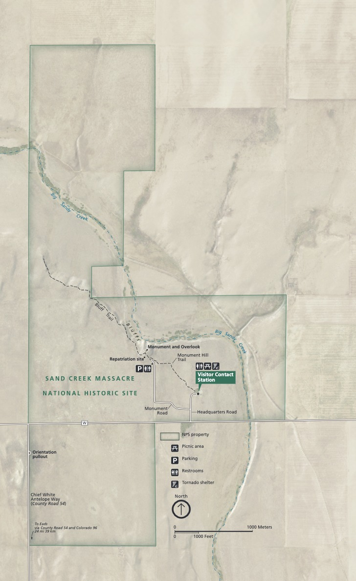 Map of Sand Creek Massacre National Historic Site in Colorado. Shown against tan terrain and overlapping the blue Big Sandy Creek, a blocky green border encloses a Visitor Contact Station and other sites and amenities.