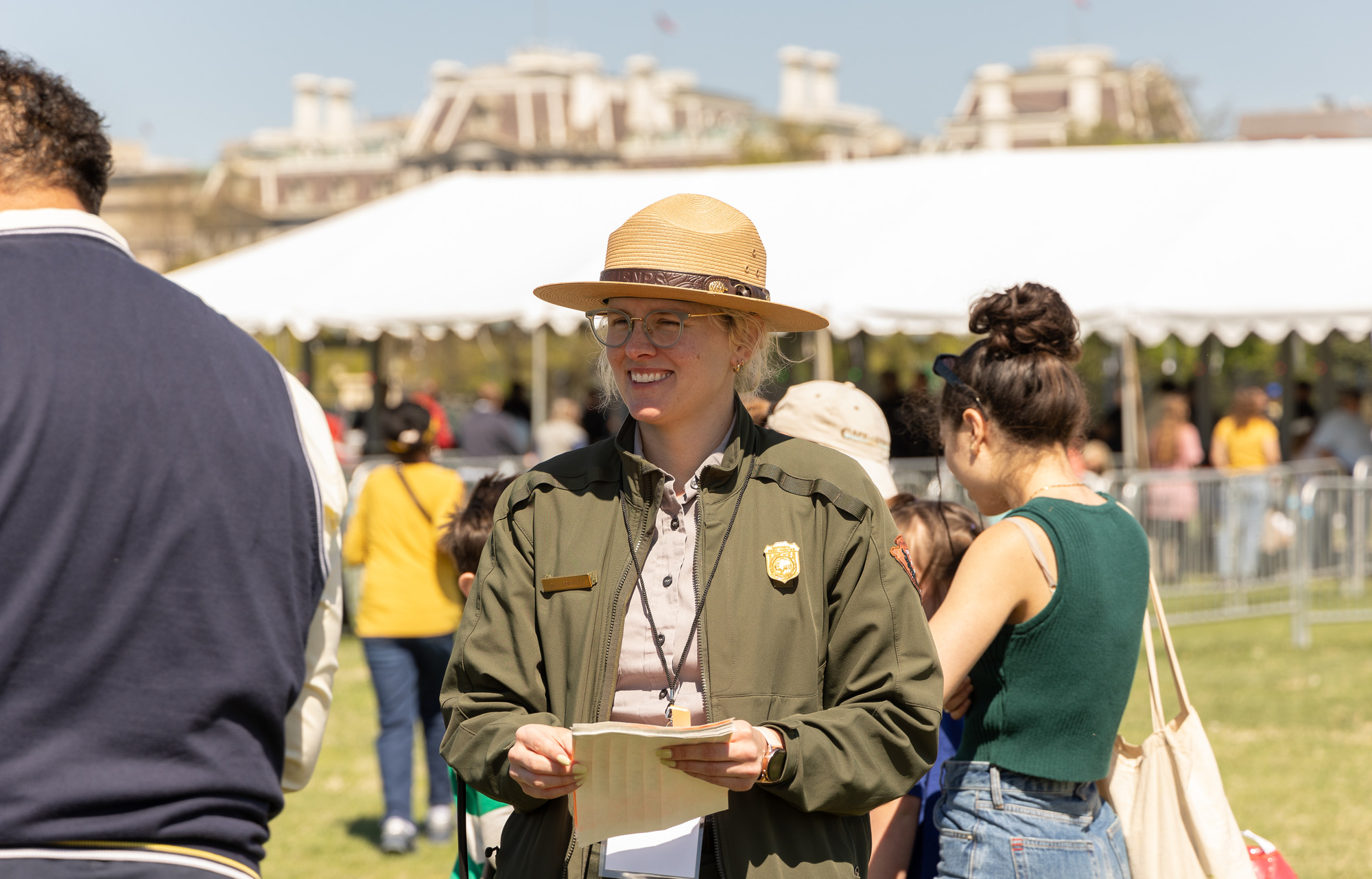 A park ranger hands out wrist bands to visitors
