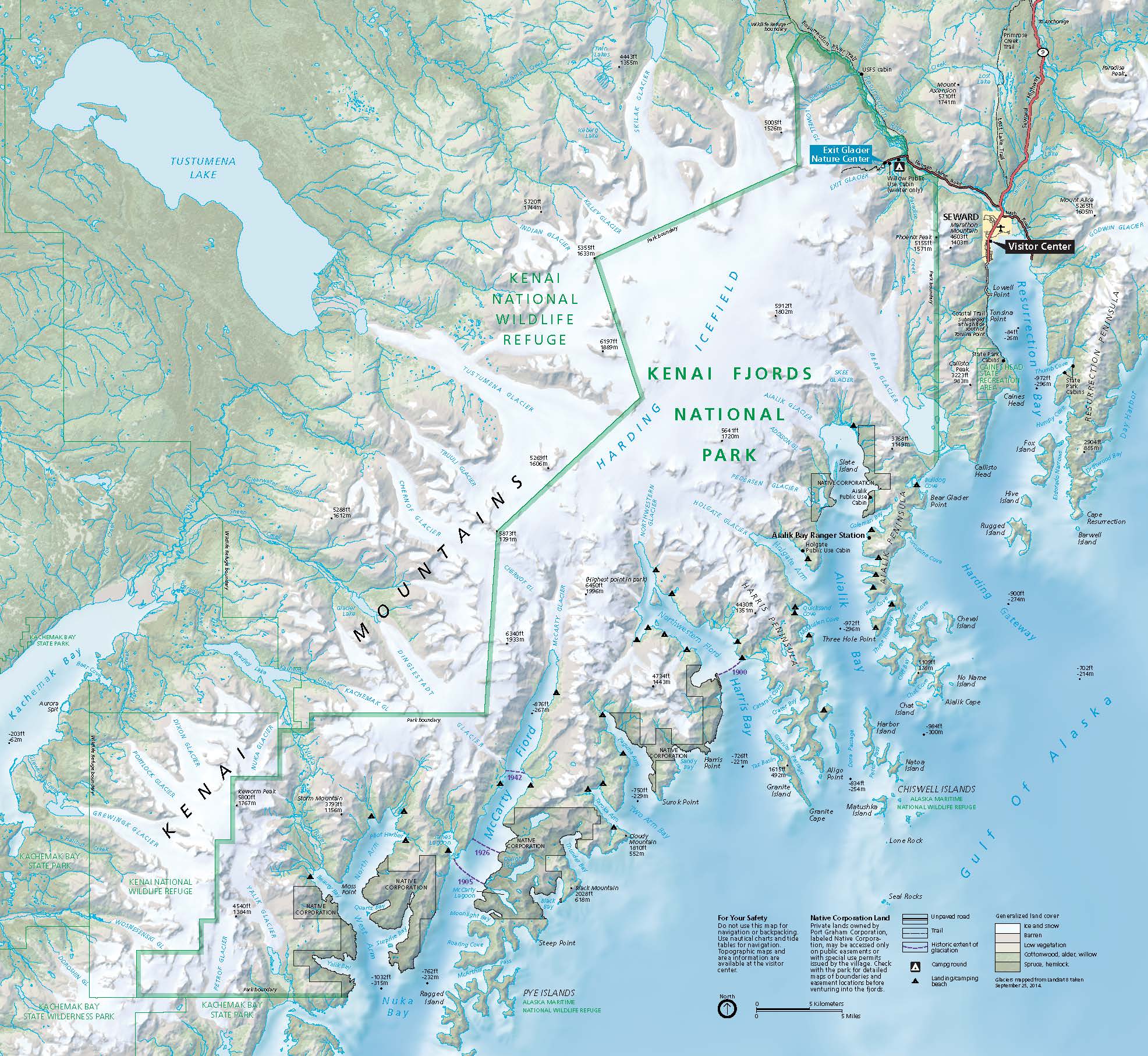Map of Kenai Fjords National Park, which stretches along the southwest coast of the Kenai Peninsula in Alaska. The land is shown green at lower elevations and is frosted with white at higher altitudes, and the water has shades of blue, representing differences in water depth. A zigzagging green outline marks the border between the Kenai National Wildlife Refuge to the west and Kenai Fjords National Park to the east.