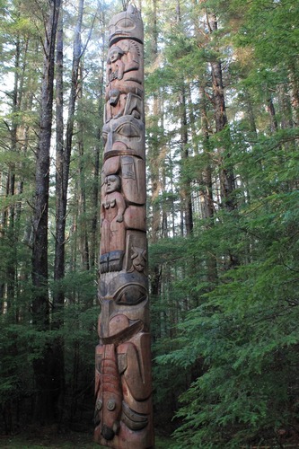 The figure in the center of this massive totem pole shows a bear holding a woman.  