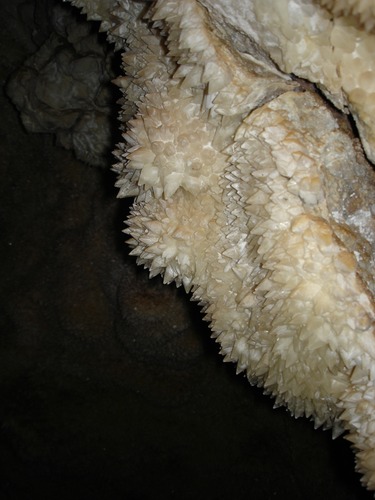 Pointed white crystals in a dark cave