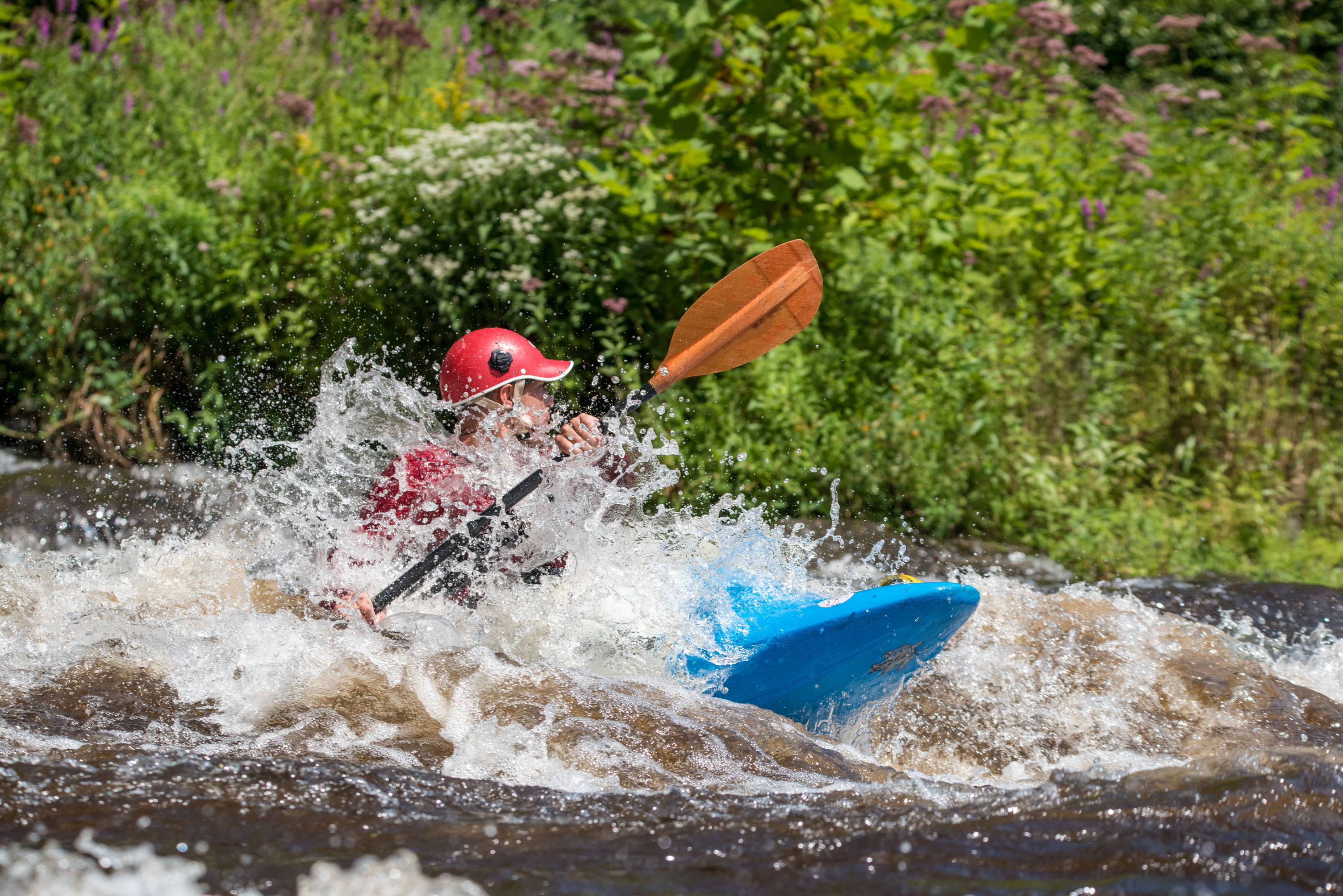 A kayaker rides a river's white water rapids