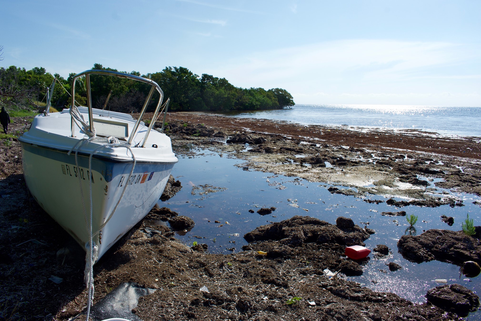 A shipwrecked sailboat on a rocky beach