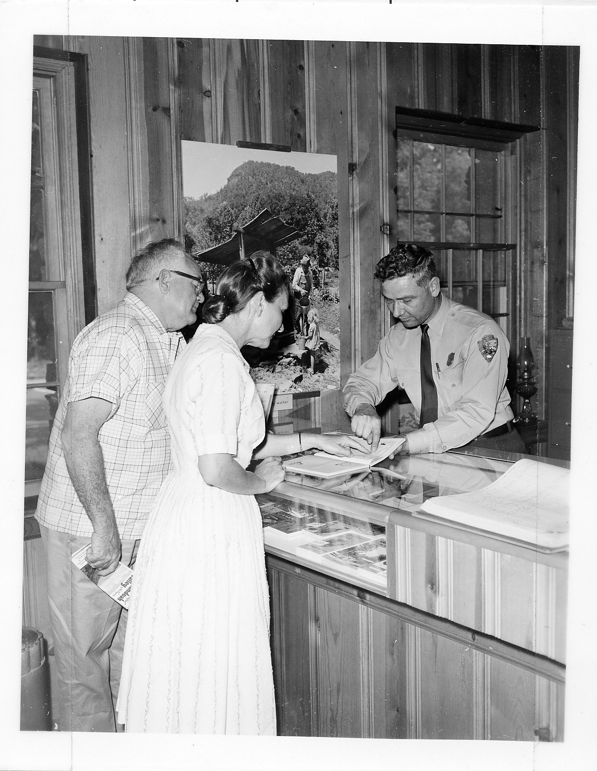 Park ranger helps visitor by pointing at a map