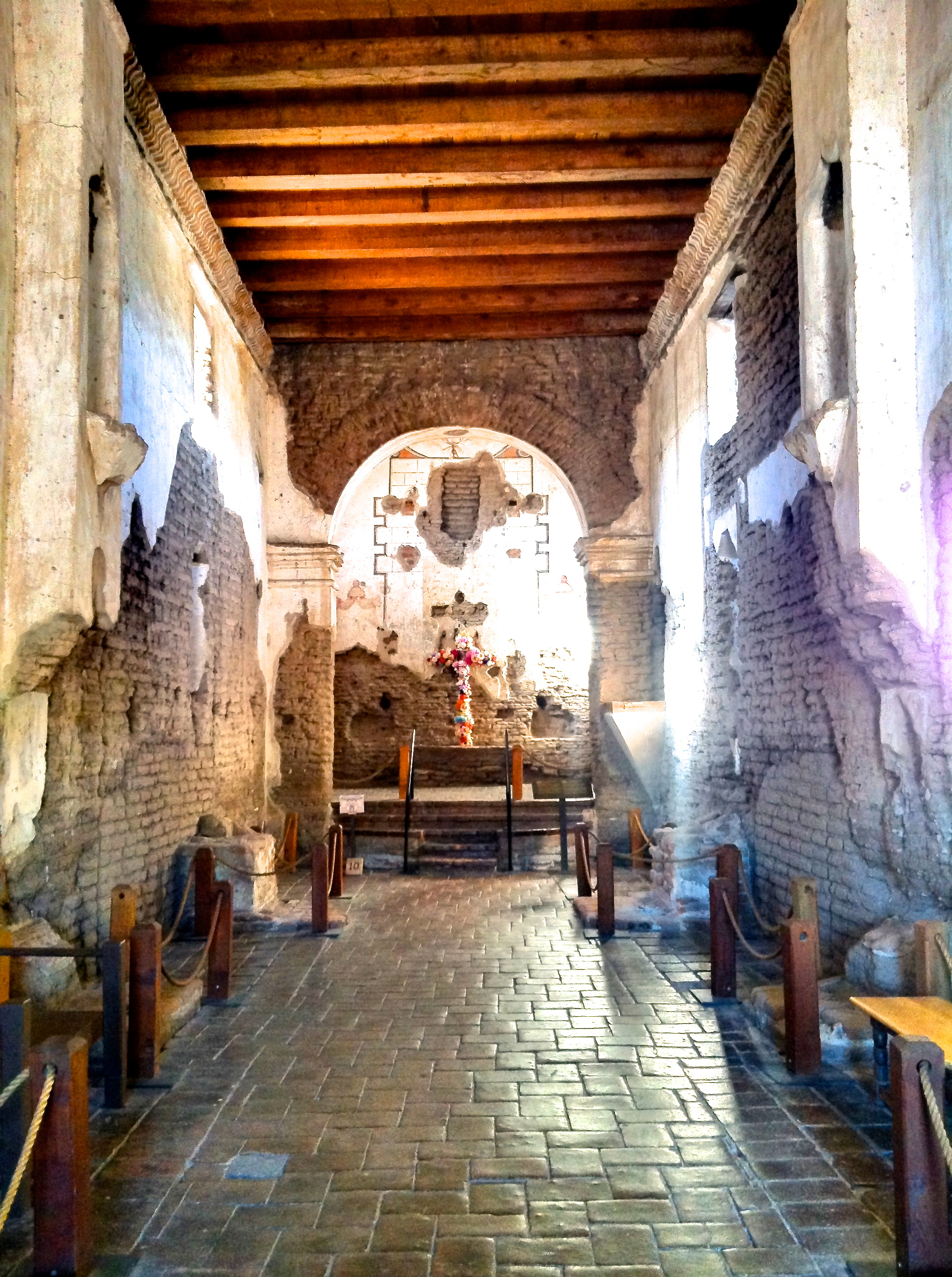 long nave with arched opening to sanctuary and flowered cross on an altar