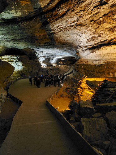 A group gathers in a large cave room. 