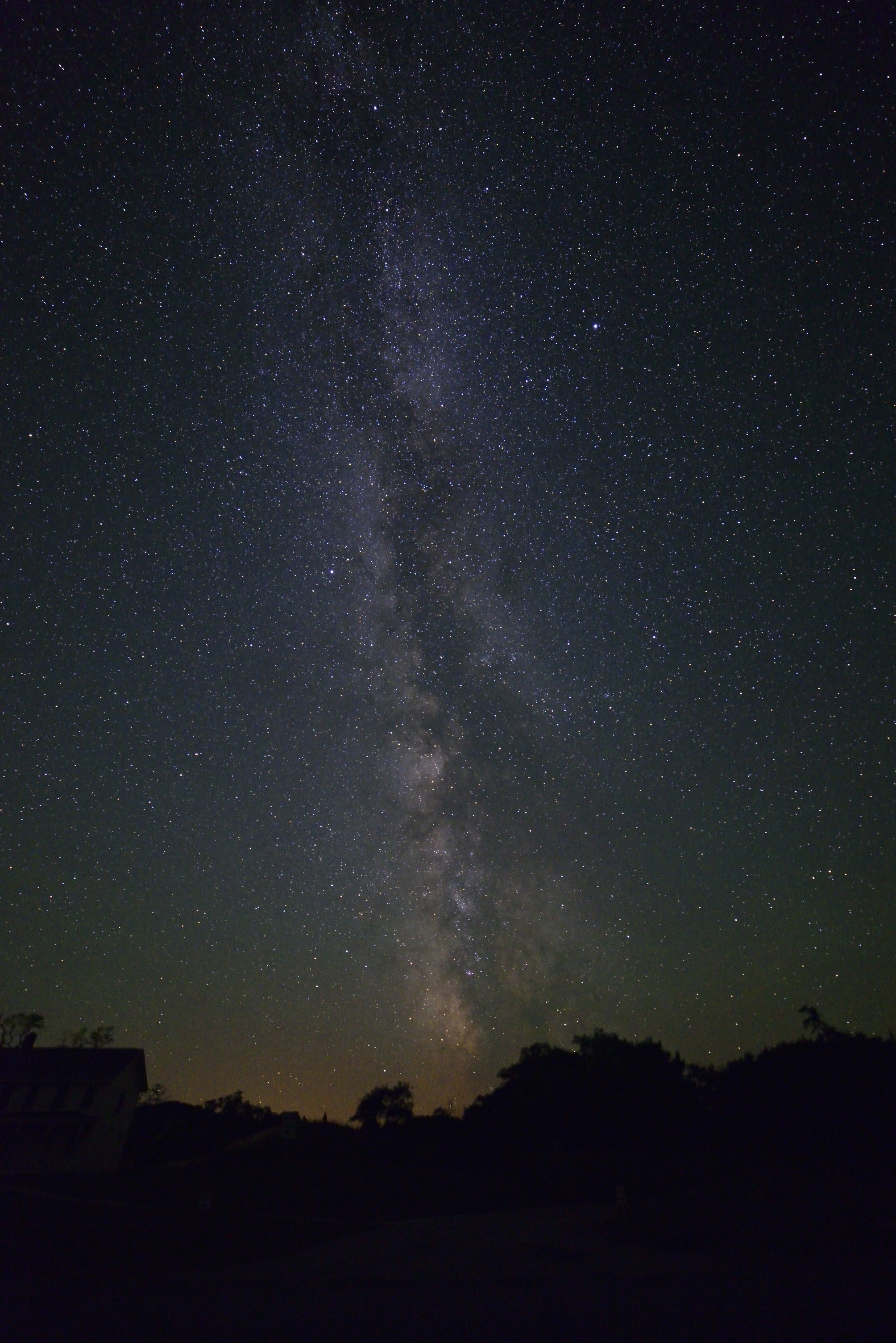 The Milky Way galaxy arcing over the silhouetted buildings and beach at Glen Haven on Lake Michigan on a clear dark night