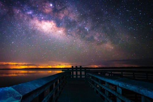 The Milky Way is visible in the starry-filled night sky over the boardwalk at West Lake.