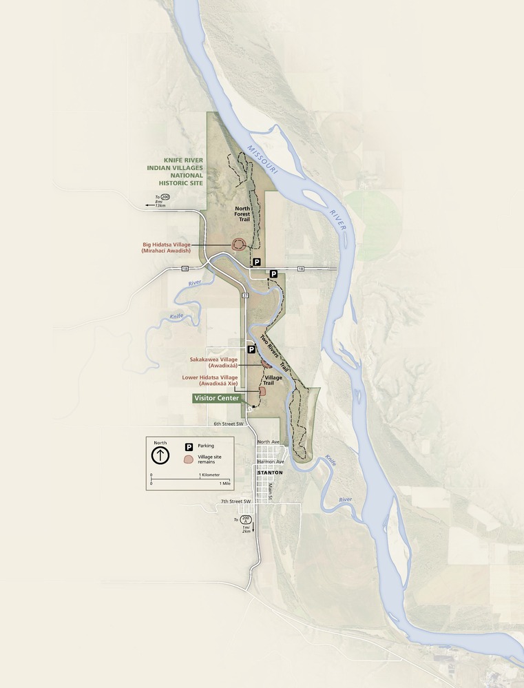Map of Knife River Indian Villages National Historic Site in North Dakota. The narrow strip of parkland is brown, and the surrounding land is light beige and shaded to show the terrain. The Knife River, shown in blue, snakes east through the parkland and south, where it joins the Missouri River, which runs parallel to the parkland.