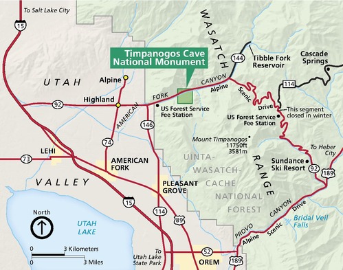 Map of Timpanogos Cave National Monument Utah. The park is a darker green square in the much larger Uinta-Wasatch-Cache National Forest, which is shown in paler green on the right half of the map. Utah Valley is shown in tan to the left, and Utah Lake is represented in blue in the lower corner.
