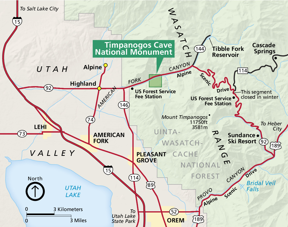 Map of Timpanogos Cave National Monument Utah. The park is a darker green square in the much larger Uinta-Wasatch-Cache National Forest, which is shown in paler green on the right half of the map. Utah Valley is shown in tan to the left, and Utah Lake is represented in blue in the lower corner.