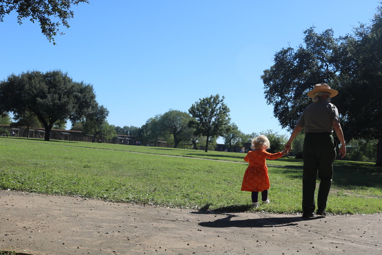Park Ranger walking with young girl.