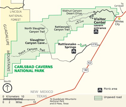 Map of Carlsbad Caverns National Park in New Mexico. The park is represented as an oblong green shape, stretching across in the west-to-east direction that tapers toward the top, with staircase-like staggered boundaries. A chunk of land shaded yellow that runs down most of the left edge from the top corner is labeled Lincoln National Forest. The Guadalupe Mountains run down the western edge of the map through both the national park and national forest.