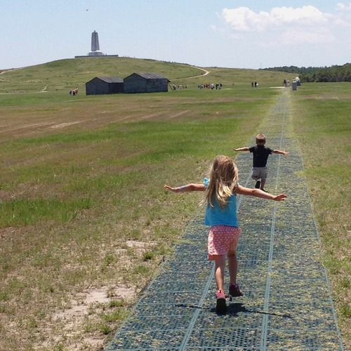 Two young visitors running down the flightpath