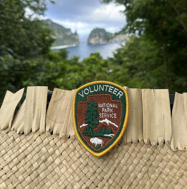 Outdoors; Upclose of patch on woven material with nature background.